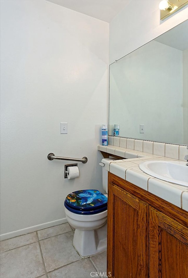 bathroom with vanity, baseboards, toilet, and tile patterned flooring