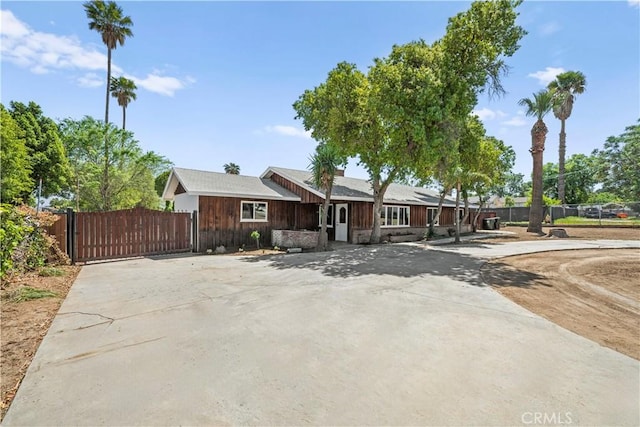 ranch-style house with a gate, driveway, and fence