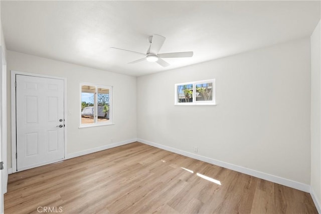 unfurnished room featuring light wood-type flooring, a ceiling fan, and baseboards