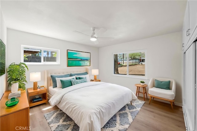 bedroom featuring ceiling fan, light wood finished floors, and a closet