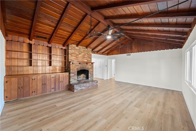 unfurnished living room with vaulted ceiling with beams, a ceiling fan, wood finished floors, a brick fireplace, and wooden ceiling