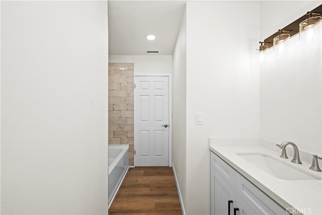 bathroom with visible vents, wood finished floors, vanity, and recessed lighting