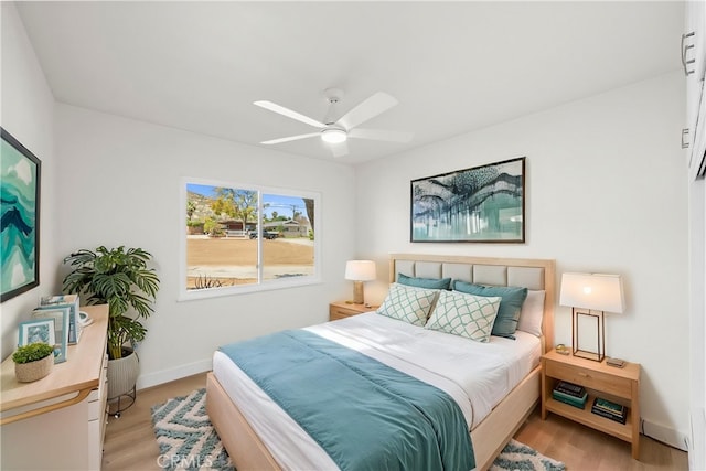 bedroom featuring ceiling fan, baseboards, and light wood-type flooring