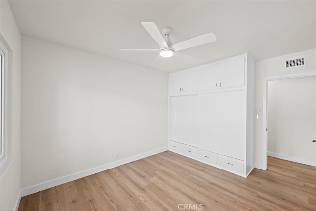 unfurnished bedroom with baseboards, light wood finished floors, and visible vents