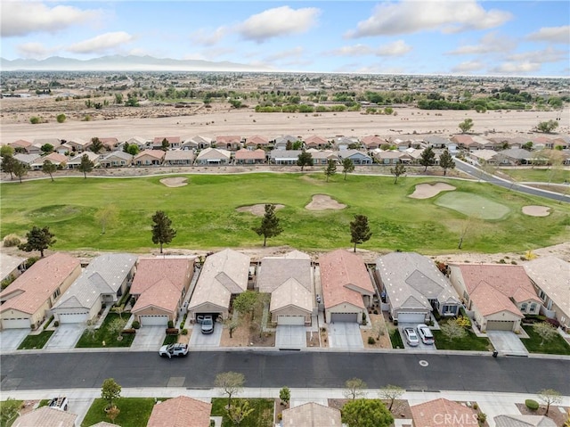 drone / aerial view featuring view of golf course, a mountain view, and a residential view