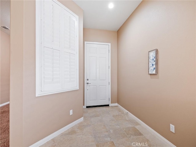 doorway featuring baseboards