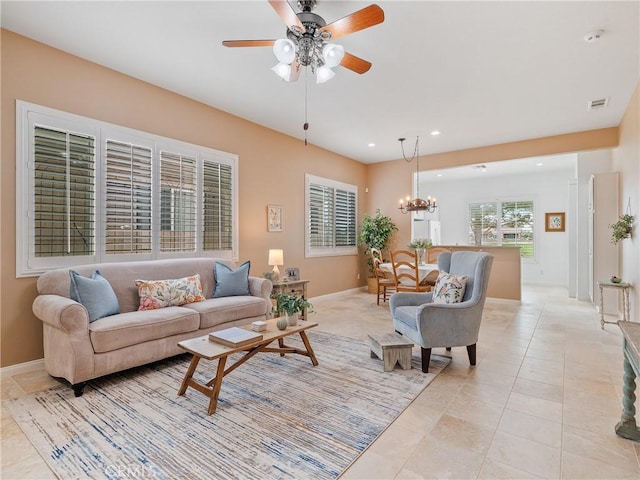 living room with light tile patterned flooring, baseboards, visible vents, recessed lighting, and ceiling fan with notable chandelier