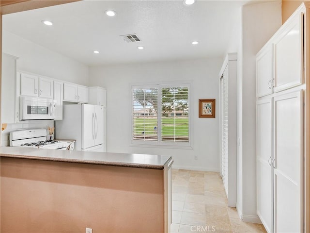 kitchen with recessed lighting, visible vents, white appliances, a peninsula, and white cabinetry