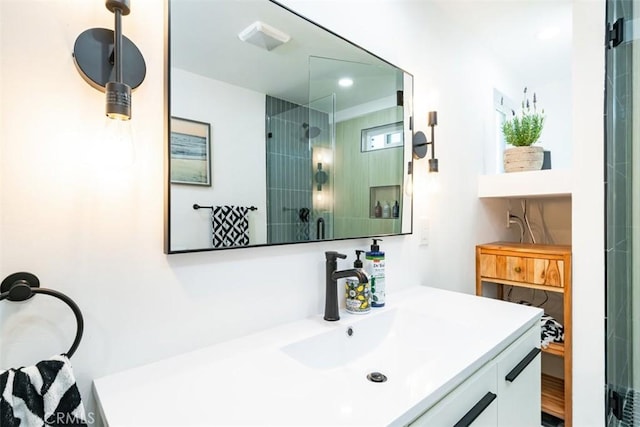 bathroom featuring recessed lighting, a tile shower, and vanity