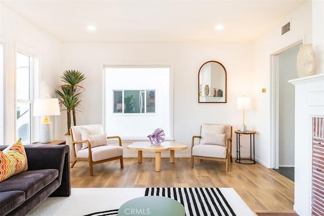 living area featuring recessed lighting, light wood-type flooring, visible vents, and baseboards