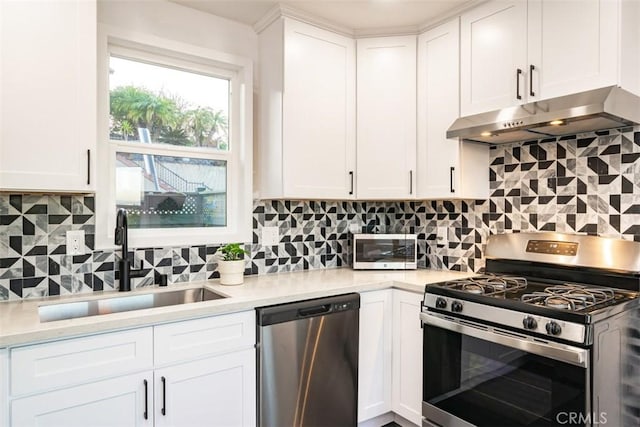 kitchen with under cabinet range hood, stainless steel appliances, light countertops, and a sink