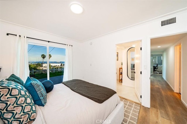 bedroom featuring crown molding, wood finished floors, access to exterior, and visible vents