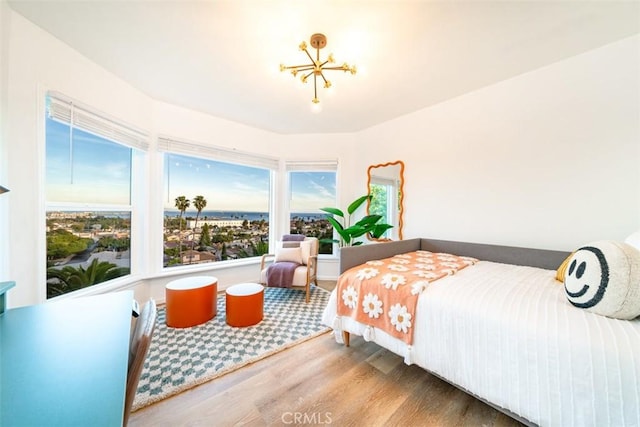bedroom with wood finished floors and a notable chandelier