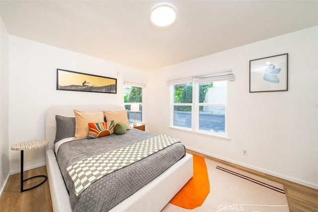 bedroom featuring baseboards and wood finished floors