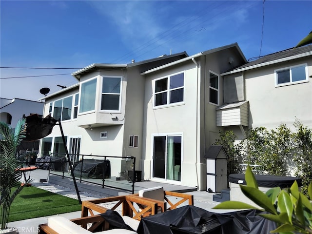 back of property featuring a patio area and stucco siding