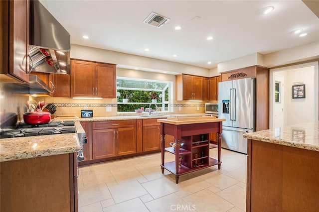 12843 Sarah St, Studio City, CA 91604 - kitchen with appliances with stainless steel finishes, wall chimney exhaust hood, backsplash, light stone countertops, and open shelves
