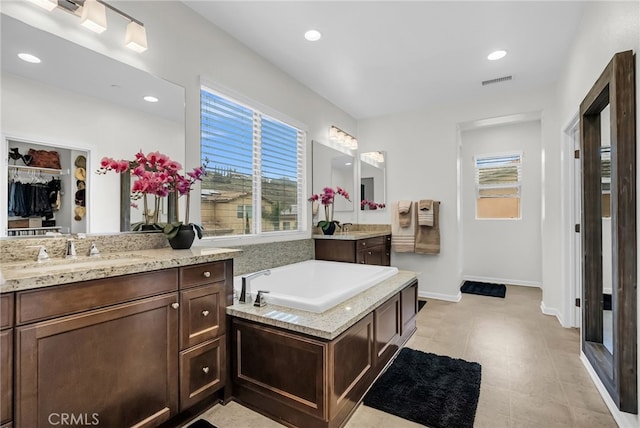 25889 Basil Ct, Corona, CA 92883 - full bath featuring two vanities, recessed lighting, a garden tub, a walk in closet, and baseboards