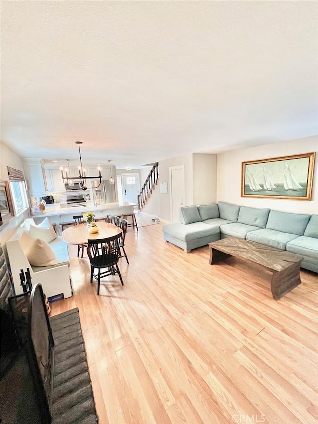 82 Avalon Terrace Rd, Avalon, CA 90704 - living room with a notable chandelier, stairs, and light wood-type flooring