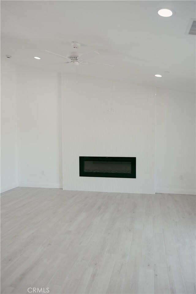 7452 Chase Ave, Hesperia, CA 92345 - unfurnished living room with a glass covered fireplace, ceiling fan, wood finished floors, baseboards, and recessed lighting