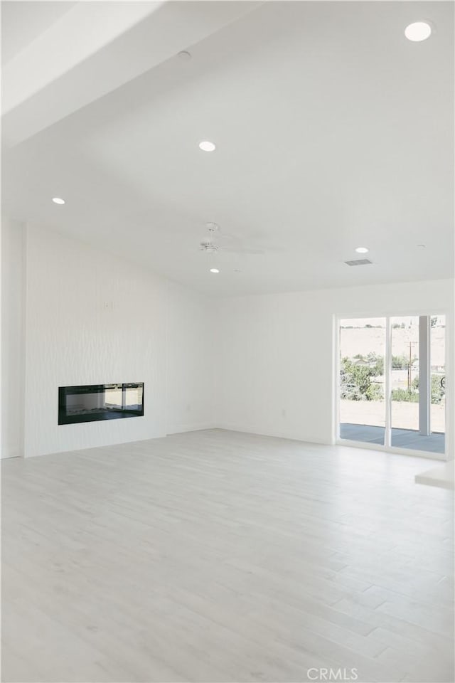 7452 Chase Ave, Hesperia, CA 92345 - unfurnished living room with light wood-style flooring, a glass covered fireplace, and recessed lighting