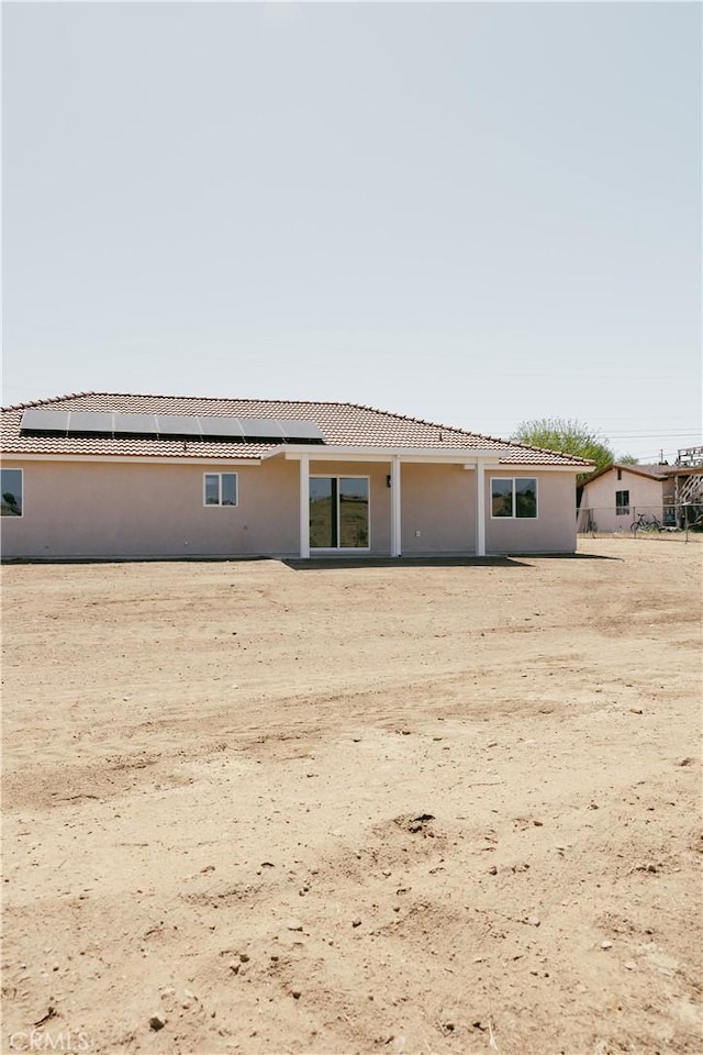 7452 Chase Ave, Hesperia, CA 92345 - back of house with roof mounted solar panels and stucco siding