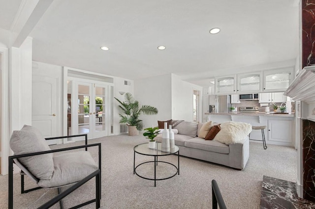 living area with light carpet, french doors, and recessed lighting