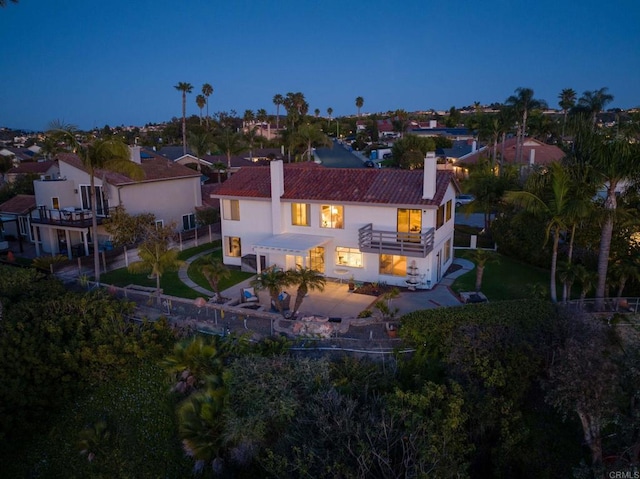 rear view of house with a chimney, a fenced backyard, stucco siding, a patio area, and a tile roof