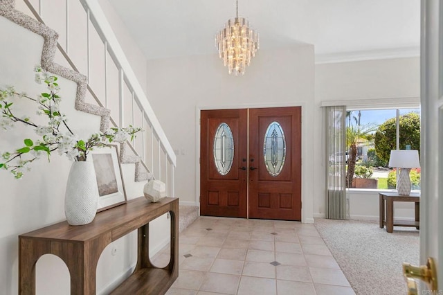entryway featuring an inviting chandelier, light tile patterned floors, french doors, baseboards, and stairs