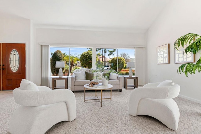 carpeted living area featuring baseboards and plenty of natural light