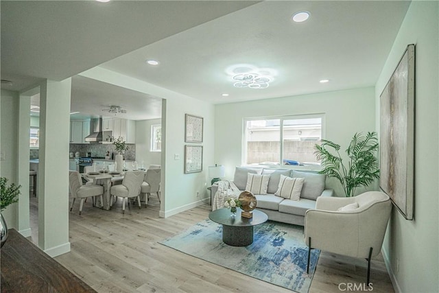 living room featuring light wood finished floors, baseboards, and recessed lighting