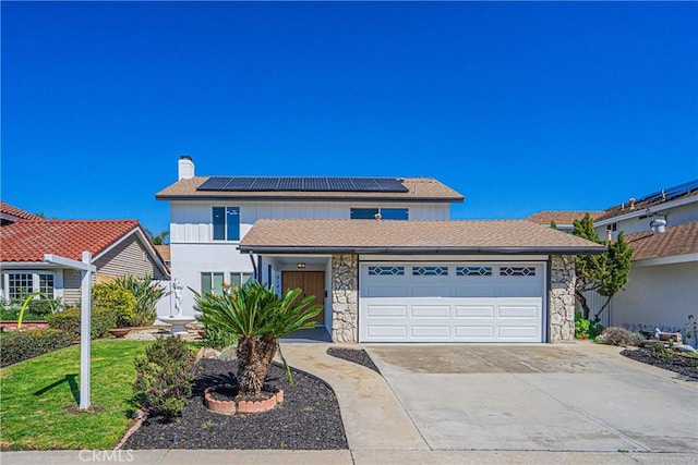 traditional-style home with a chimney, driveway, stone siding, a garage, and solar panels
