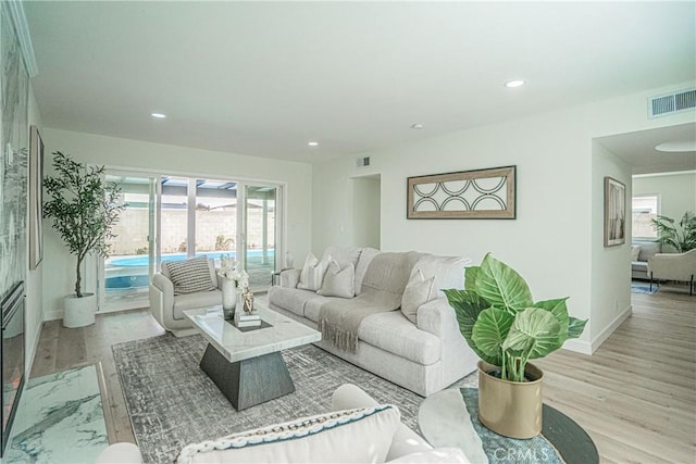 living room with recessed lighting, light wood-style flooring, visible vents, and a healthy amount of sunlight