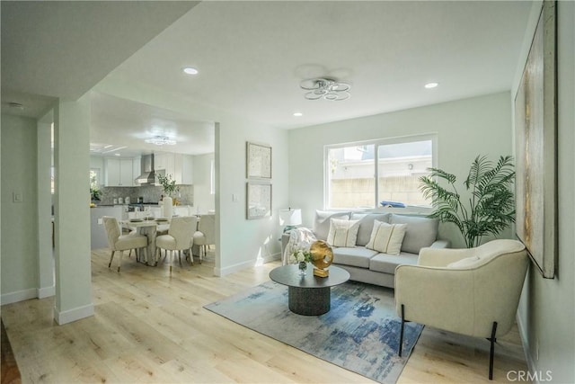 living area featuring baseboards, light wood-style floors, and recessed lighting