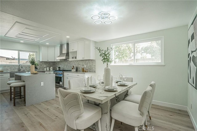 dining room featuring recessed lighting, light wood-style flooring, and baseboards
