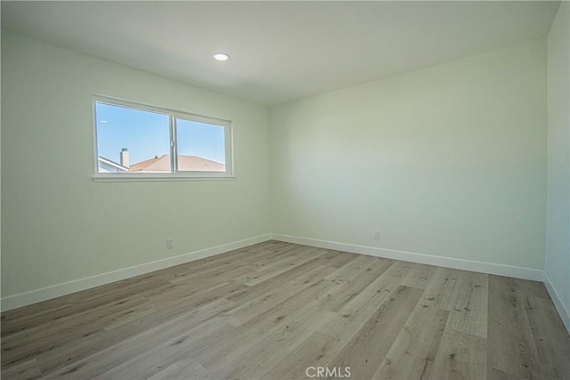 unfurnished room with light wood finished floors, baseboards, and recessed lighting