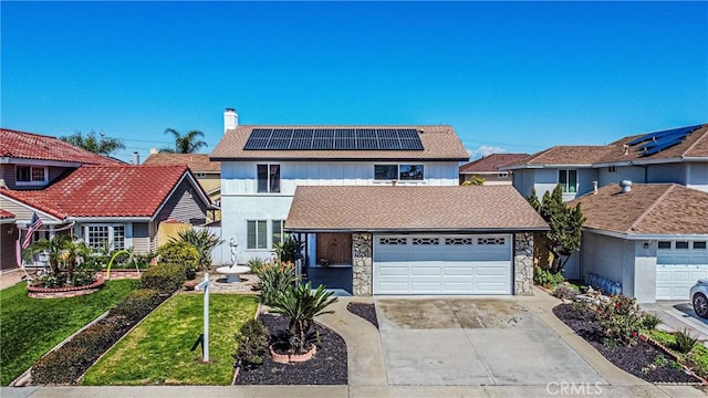 traditional-style house with roof mounted solar panels, driveway, a chimney, and stone siding