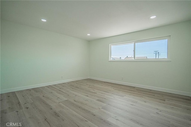 spare room with light wood-style flooring, baseboards, and recessed lighting