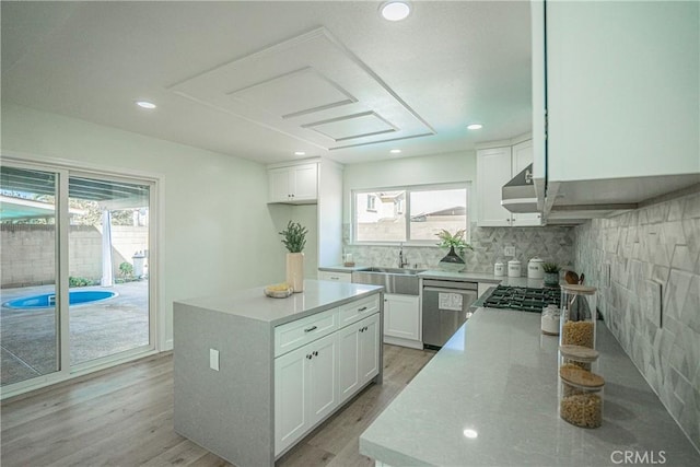 kitchen featuring decorative backsplash, appliances with stainless steel finishes, white cabinetry, and a sink