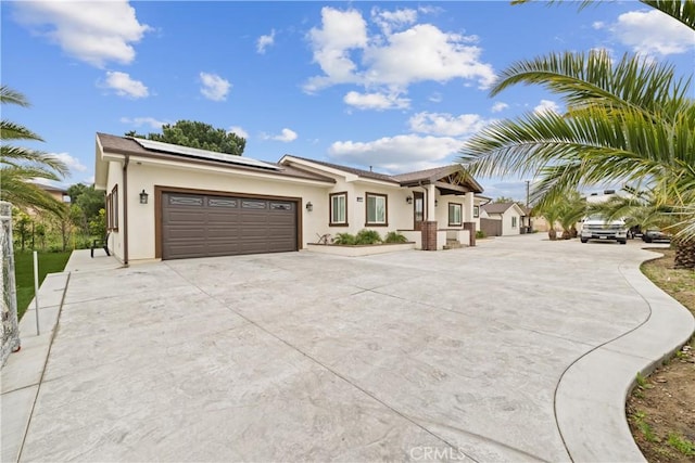 9614 Cypress Ave, Fontana, CA 92335 - view of front of home featuring driveway, an attached garage, stucco siding, and roof mounted solar panels