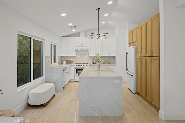 7632 Penobscot Dr, West Hills, CA 91304 - kitchen featuring vaulted ceiling, under cabinet range hood, light wood-style floors, and white appliances