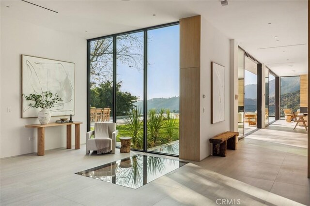 doorway to outside with plenty of natural light, expansive windows, and a mountain view