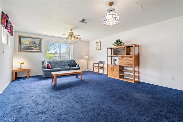 carpeted living room with visible vents and ceiling fan