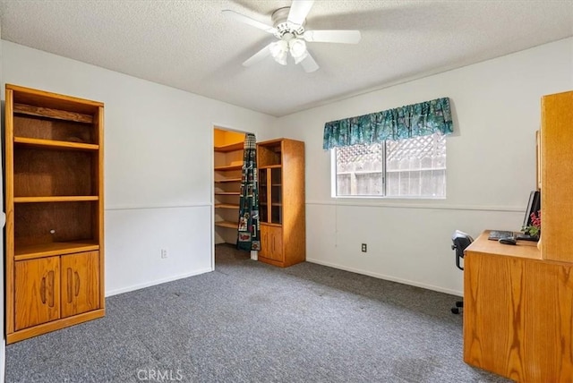 unfurnished bedroom featuring a spacious closet, carpet floors, a textured ceiling, and baseboards