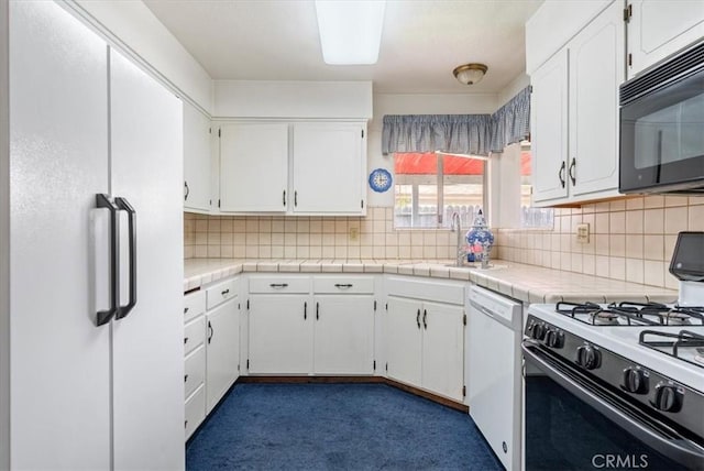 kitchen with white cabinets, a sink, decorative backsplash, and white appliances