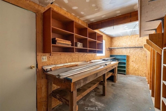interior space featuring unfinished concrete floors and a workshop area