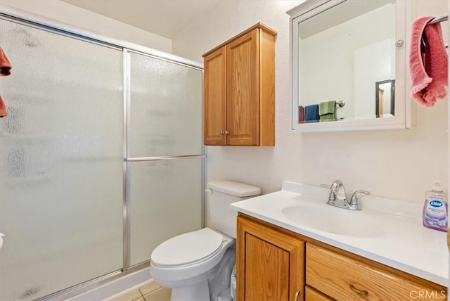 full bathroom featuring a shower stall, toilet, vanity, and tile patterned flooring
