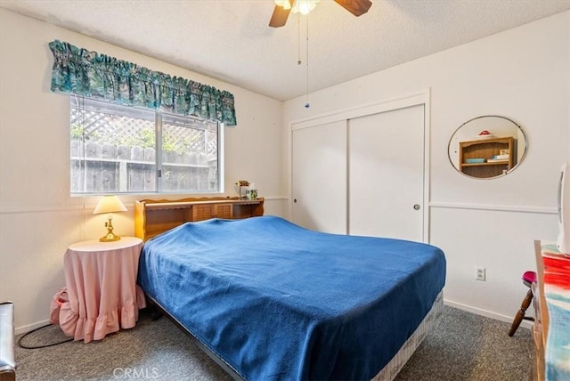 carpeted bedroom with a ceiling fan, baseboards, a textured ceiling, and a closet