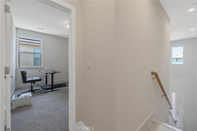 corridor with visible vents, baseboards, carpet floors, and an upstairs landing