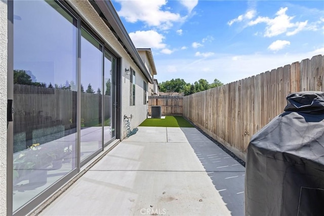 view of patio / terrace with cooling unit and a fenced backyard