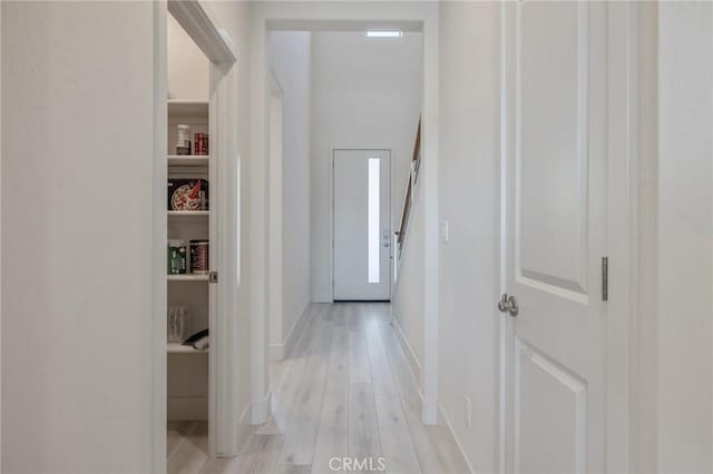 hall featuring light wood-style floors and baseboards